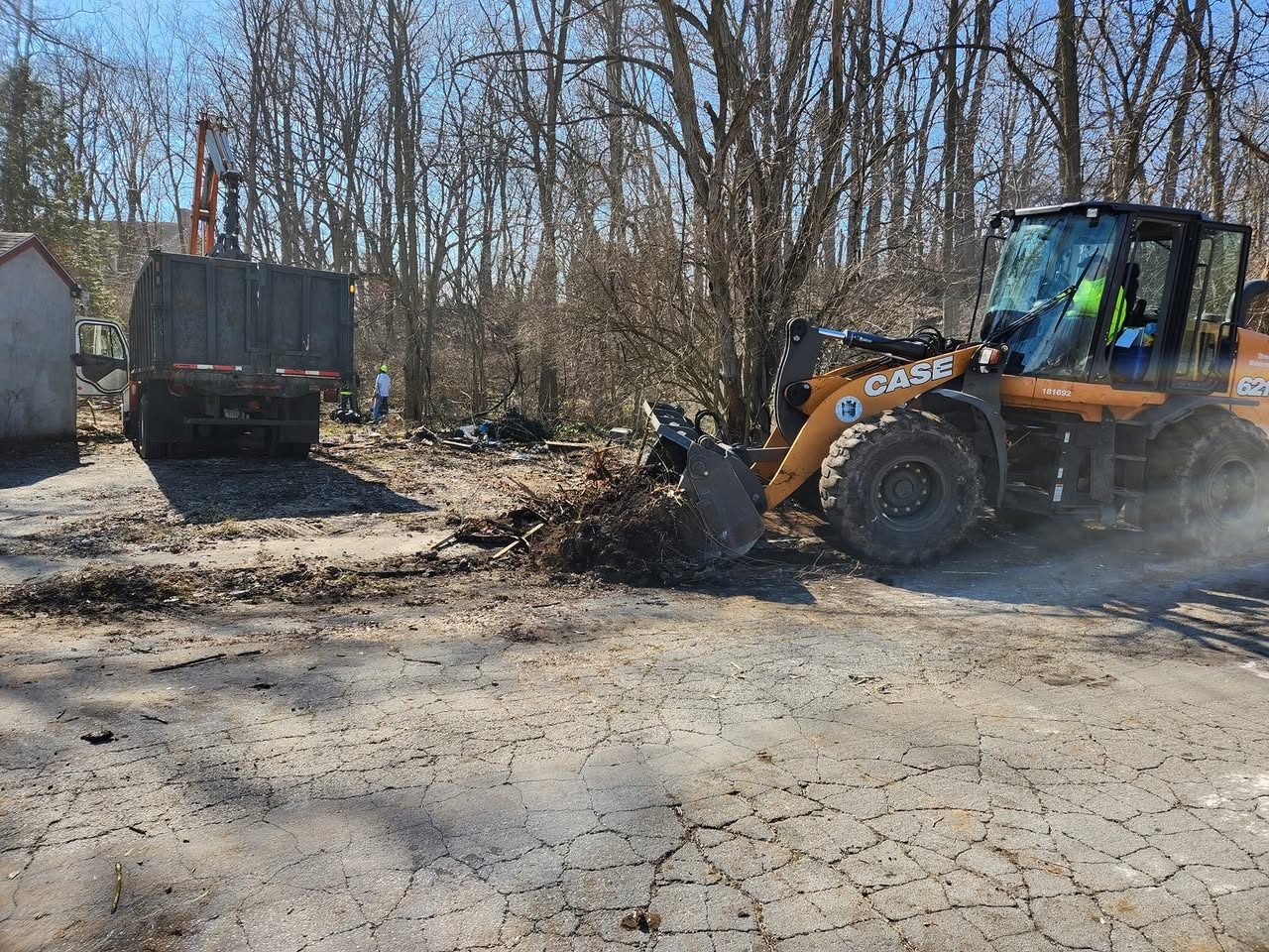 A loader scoops out an illegal dump