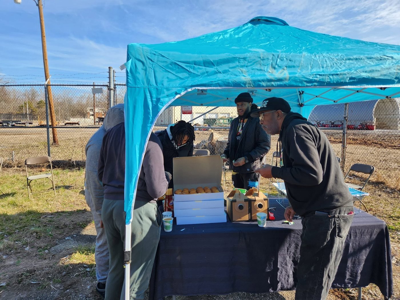 Neighbors gathered under a tent at a Do Not Be A Litterbug community event